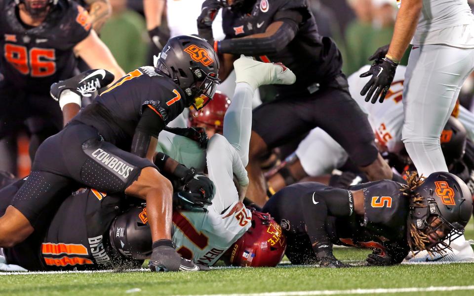 Nov 12, 2022; Stillwater, Oklahoma, USA; Oklahoma State's Jabbar Muhammad (7), Lamont Bishop (11) and Kendal Daniels (5) stop Iowa State's Hunter Dekkers (12) on a fourth down late in the fourth quarter during the college football game between the Oklahoma State Cowboys (OSU) and the Iowa State Cyclones at Boone Pickens Stadium. OSU won 20-14. Mandatory Credit: Sarah Phipps-USA TODAY Sports