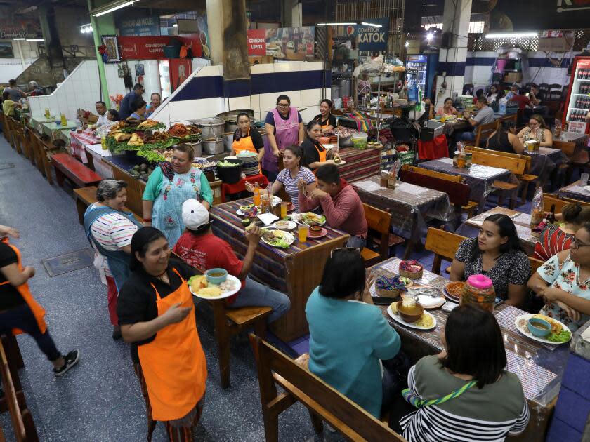 Guests eat in a food court with a variety of different restaurants serving different types of food.