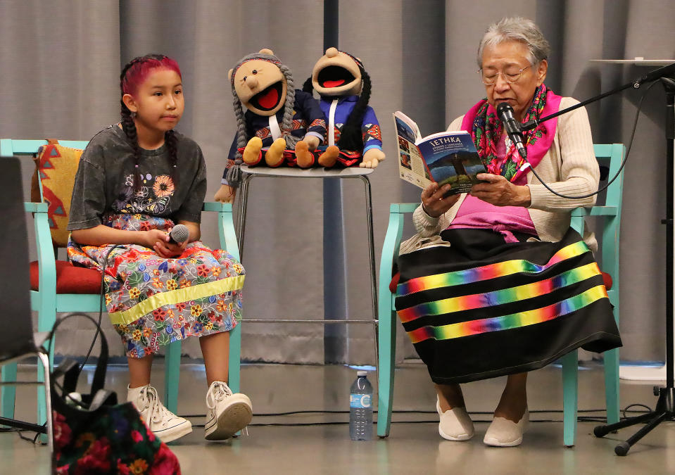 Tina Fox, right, reads an excerpt from "Îethka Stories & Language in Stoney Nakoda Country" alongside great-granddaughter, Heavenly Fox, 10, at the book's launch event at the Calgary Public Library on Friday (June 21).