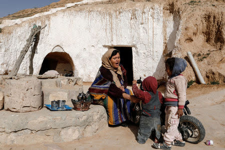 Saliha Mohamedi, 36, talks with her daughters after finishing her housework, outside of her troglodyte house on the outskirts of Matmata, Tunisia, February 5, 2018. "I don't want to leave my house, it would be as if I was throwing my life and my traditions away," Saliha said. REUTERS/Zohra Bensemra