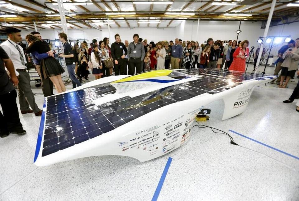 People take videos and photos of the “Dawn” solar car, designed by members of Cal Poly’s Prototype Vehicles Laboratory and unveiled Saturday, April 8, 2018, at the Empirical System Aerospace facility in San Luis Obispo.