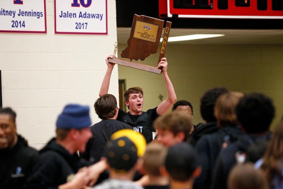 Saint Joseph junior Chase Konieczny lifts the trophy amongst a sea of people after the Huskies beat Delta, 44-41 (3OT), in an IHSAA Class 3A boys basketball semistate championship game Saturday, March 16, 2024, at Logansport High School.