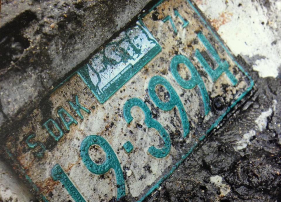 In this undated photo provided by the South Dakota Attorney Generals Office, a license plate from the 1960 Studebaker unearthed in September, 2013 is seen. Two South Dakota girls on their way to an end-of-school-year party at a gravel pit in May 1971 drove off a country road into a creek and remained hidden until last fall when a drought brought their car into view, authorities said Tuesday, April 15, 2014. State and local officials held a news conference Tuesday afternoon confirming that the 1960 Studebaker unearthed in September included the remains of Cheryl Miller and Pamella Jackson, both 17-year-olds who attended Vermillion High School. (AP Photo/South Dakota Attorney Generals Office)