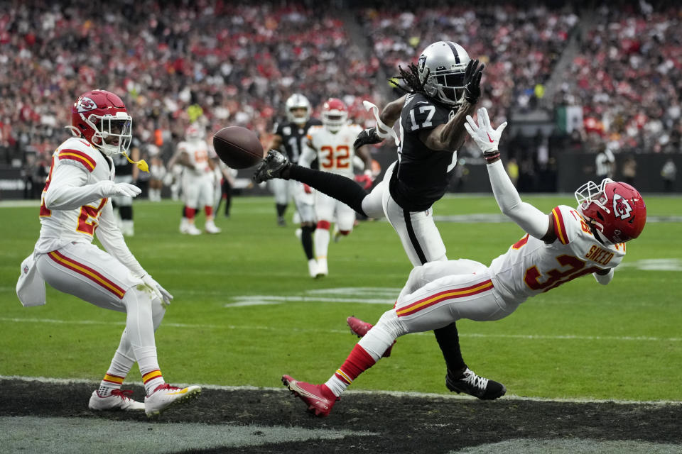 Las Vegas Raiders wide receiver Davante Adams (17) is unable to catch a pass as Kansas City Chiefs safety Juan Thornhill and cornerback L'Jarius Sneed, right, defend during the first half of an NFL football game Saturday, Jan. 7, 2023, in Las Vegas. (AP Photo/John Locher)