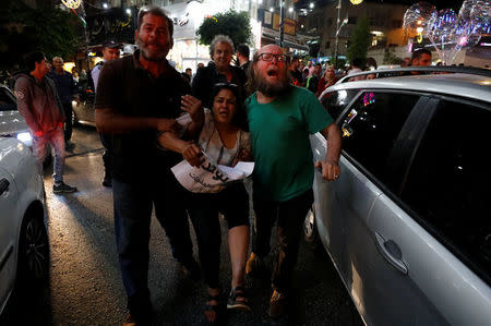 A demonstrator is evacuated during a protest calling on President Mahmoud Abbas to end financial sanctions on Palestinians in Gaza, in Ramallah, in the occupied West Bank, June 13, 2018. REUTERS/Mohamad Torokman