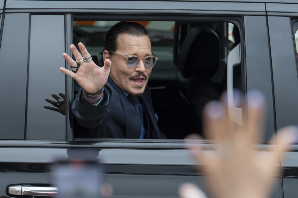 El actor Johnny Depp saluda a sus seguidores al salir del Tribunal del Condado de Fairfax el viernes 27 de mayo de 2022 en Fairfax, Virginia. Un jurado civil otorgó 10, 35 millones de dólares en indemnización a Johnny Depp en su demanda por difamación contra su exesposa Amber Heard y 2 millones de Heard por su contrademanda. (Foto AP/Craig Hudson)