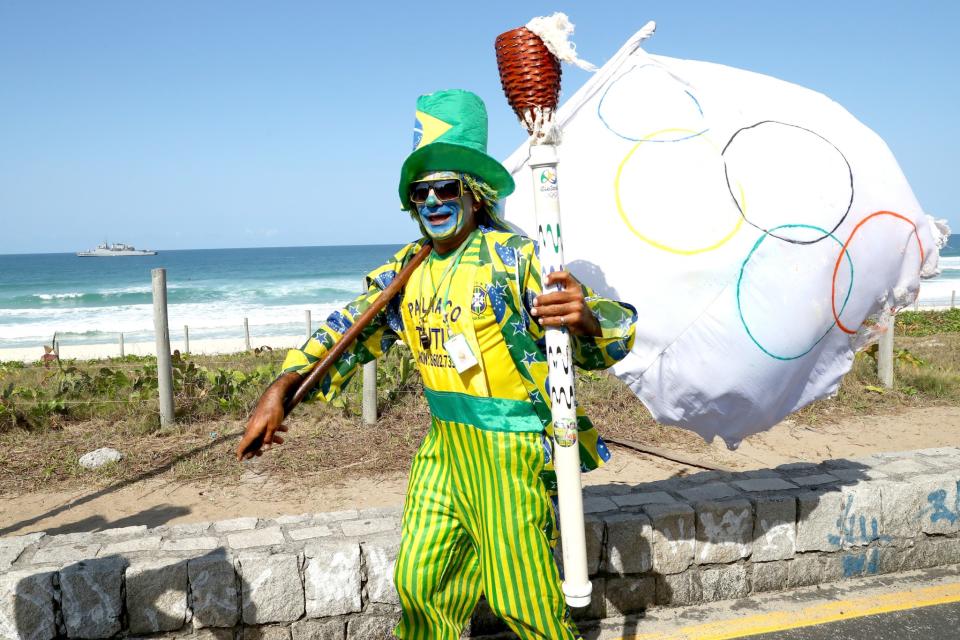 <p>A Brazilian super fan escorts the Olympic torch relay ahead of the Rio 2016 Olympic Games on August 4, 2016 in Rio de Janeiro, Brazil. (Photo by Alexander Hassenstein/Getty Images) </p>