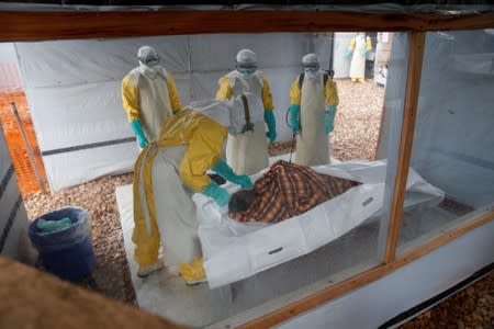 Health workers dressed in protective suits prepare the body of Congolese woman Kahambu Tulirwaho for burial after she died of Ebola, at an Ebola treatment centre in Butembo