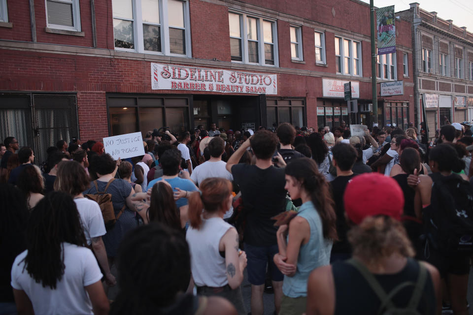 <p>Demonstrators rally outside the Sideline Studio Barber & Beauty Salon in the South Shore neighborhood protesting the shooting death of 37-year-old Harith Augustus who worked there as a barber on July 16, 2018 in Chicago, Ill. (Photo: Scott Olson/Getty Images) </p>