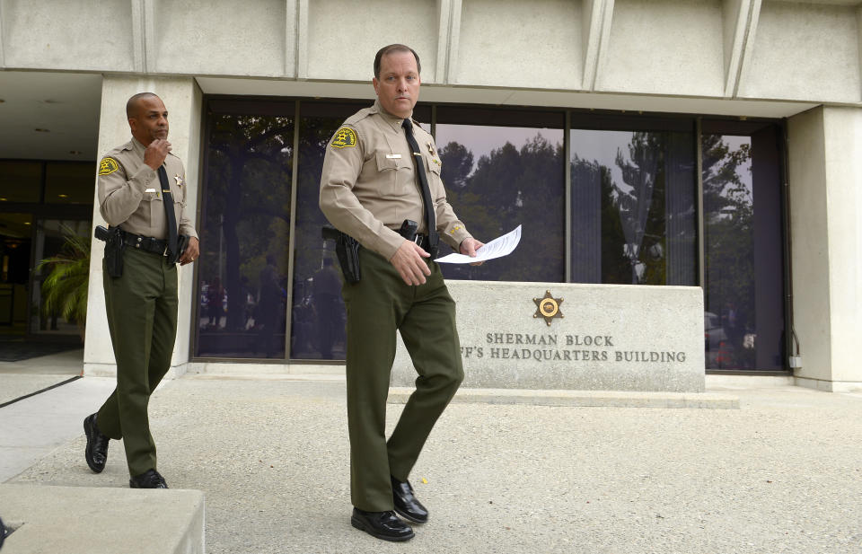 Los Angeles Sheriff's Department commander Mike Parker, right, and Capt. Roosevelt Johnson walk out to speak to reporters, Tuesday, March 25, 2014, in Los Angeles, about the death of actor Paul Walker and his friend Roger Rodas. The Porsche carrying "Fast & Furious" star Walker was traveling up to 94 mph when it went out of control on a suburban street and crashed, killing the actor and his friend, according to an investigation by law enforcement agencies into the November accident. The sports car driven by Rodas slammed into a light pole with a 45 mph speed limit sign and burst into flames. Walker and Rodas died at the scene. (AP Photo/Mark J. Terrill)