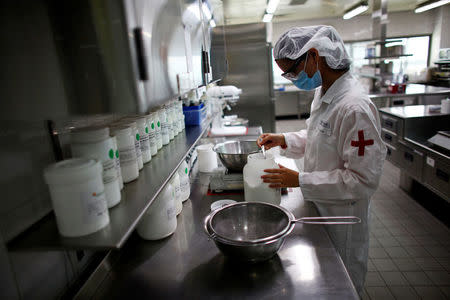 An employee works at a Nestle research and development center in Shanghai, China, October 18, 2012. REUTERS/Carlos Barria/File Photo