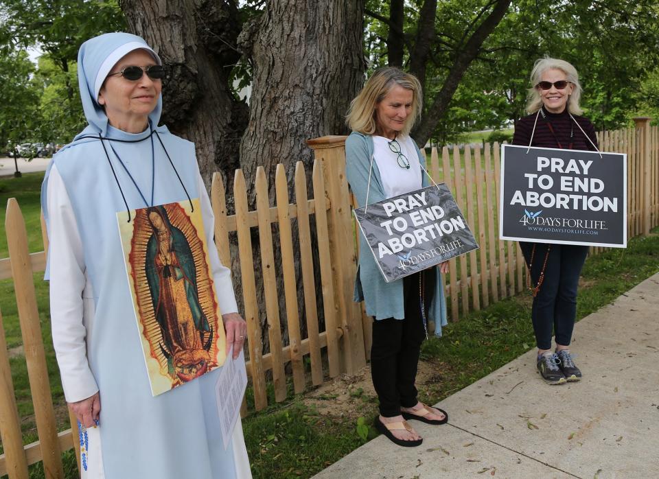Sister Mary Rose Reddy of Our Lady of the Holy Rosary and St. Leo Parishes prays for an end to abortion with two others as they stand outside the Lovering Health Center in Greenland before Sen. Maggie Hassan arrived Friday, May 27, 2022.