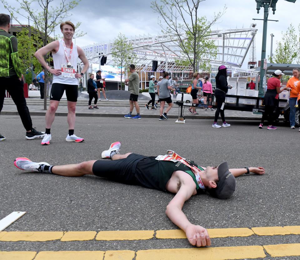 Tyler Pace, left, of Canton, first place finisher in the half marathon, looks on as his friend and second place finisher, Josh Duffie of Beaver Falls, takes a rest at the finish at the 10th Canton Hall of Fame Marathon race.