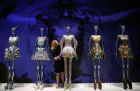 A staff member poses with dresses from the Alexander McQueen Plato's Atlantis spring/summer 2010 collection in the Alexander McQueen: Savage Beauty exhibition at the V&A in London, March 12, 2015. REUTERS/Suzanne Plunkett