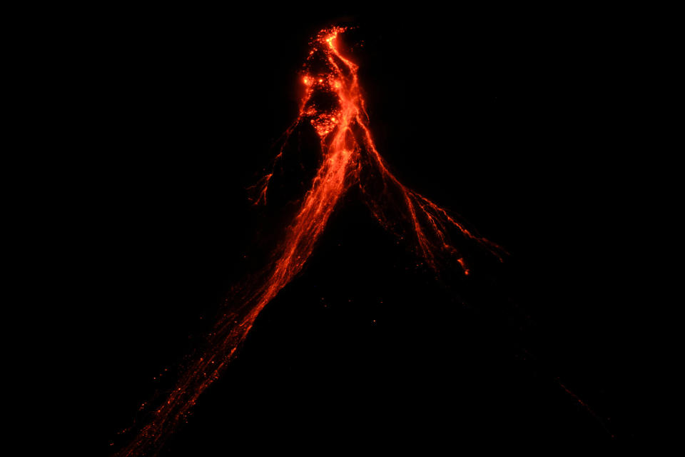 Mayon volcano belches red-hot emissions down it's slope as seen from Legaspi, Albay province, northeastern Philippines, Sunday, June 11, 2023. Albay was placed under a state of calamity last week to allow more rapid disbursement of emergency funds in case a major eruption unfolds. (AP Photo/Aaron Favila)