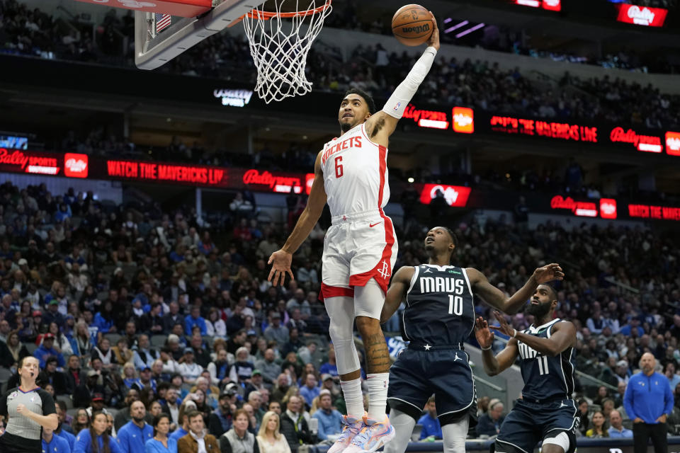 Houston Rockets forward Kenyon Martin Jr. (6) scores against Dallas Mavericks defenders Dorian Finney-Smith (10) and Tim Hardaway Jr. (11) during the second half of an NBA basketball game in Dallas, Wednesday, Nov. 16, 2022. The Rockets won 101-92. (AP Photo/LM Otero)