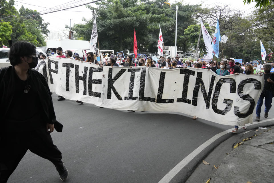 Protesters hold a banner as they march during a rally as they commemorate International Human Rights Day, Saturday, Dec. 10, 2022, in Manila, Philippines. Hundreds of people marched in the Philippine capital on Saturday protesting what they said was a rising number of extrajudicial killings and other injustices under the administration of President Ferdinand Marcos Jr. (AP Photo/Aaron Favila)