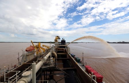 FILE PHOTO: A dredging boat sprays sand at the shore on the Parana river near Rosario, Argentina