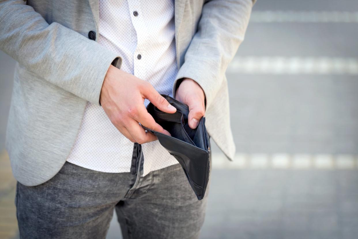 Man holding open his empty wallet