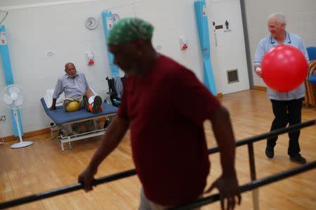 Eric Blackman (L) and Ira Hutchinson (C) participate in a physiotherapy class for amputees in the Physiotherapy department at Milton Keynes University Hospital in Milton Keynes, central England, Britain, June 8, 2018. REUTERS/Hannah McKay