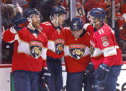 Florida Panthers left wing Jonathan Huberdeau (11), defenseman Gustav Forsling (42), center Eetu Luostarinen (27) and right wing Claude Giroux (28) celebrate a goal against the Tampa Bay Lightning during the second period of Game 2 of an NHL hockey second-round playoff series Thursday, May 19, 2022, in Sunrise, Fla. (AP Photo/Reinhold Matay)