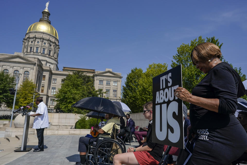 A woman prays in support of Fulton County District Attorney Fani Willis and others inside the court system during a prayer vigil and rally, Wednesday, Aug. 23, 2023, in Atlanta. (AP Photo/Mike Stewart)