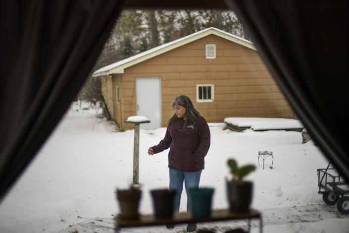 Rachel Taylor smokes a cigarette outside the home she shared with her son, Kyle Domrese, in Bemidji, Minn., Wednesday, Nov. 17, 2021. Domrese died of a drug overdose in January. For a time, she didn't want to live without him. The medicine man took her to a sweat lodge on the reservation. When she came out, the chatter of two cranes on the wind sounded like a crow, a sign from her son. She decided that day to live. (AP Photo/David Goldman)