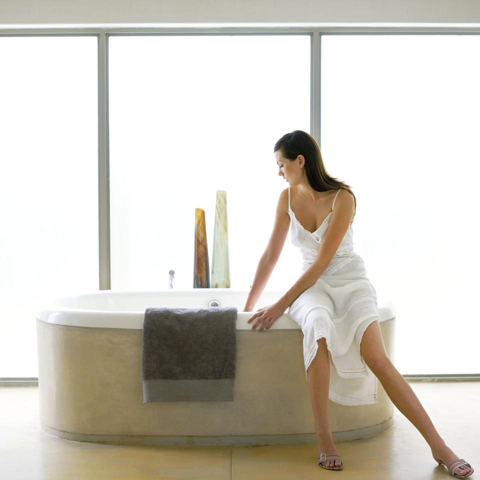 woman sitting on the edge of a bathtub