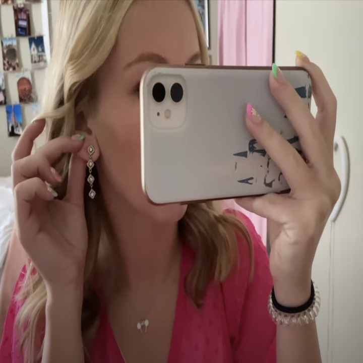 A young woman taking a selfie of her earring