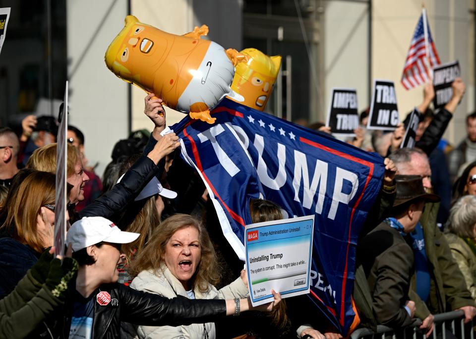 Protestors hold signs during a rally against US President Donald Trump, near the Veterans Day Parade on Nov. 11, at 2019 in New York City. (Photo: Johannes Eisele/AFP via Getty Images)