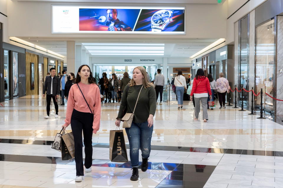 People carrying shopping bags walk inside the King of Prussia shopping mall, as shoppers show up early for the Black Friday sales, in King of Prussia, Pennsylvania, U.S. November 26, 2021.  REUTERS/Rachel Wisniewski