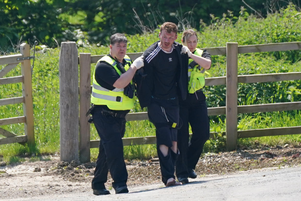 A man is detained at Hallington House Farm, on the outskirts of Louth, Lincolnshire, by officers hunting for Daniel Boulton, who is sought in connection with the deaths of a 26-year-old woman and her nine-year-old son on Monday. Picture date: Tuesday June 1, 2021.