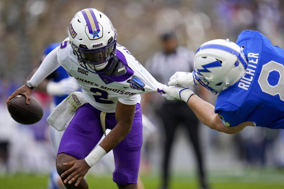 Air Force linebacker Bo Richter, right, grabs at the jersey of James Madison quarterback Jordan McCloud during the first half of the Armed Forces Bowl NCAA college football game, Saturday, Dec. 23, 2023, in Fort Worth, Texas. (AP Photo/Julio Cortez)