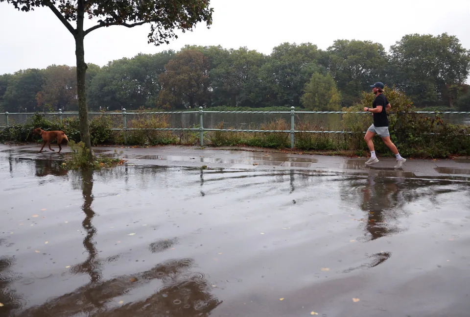 A man runs beside a flooded road by the River Thames (REUTERS)