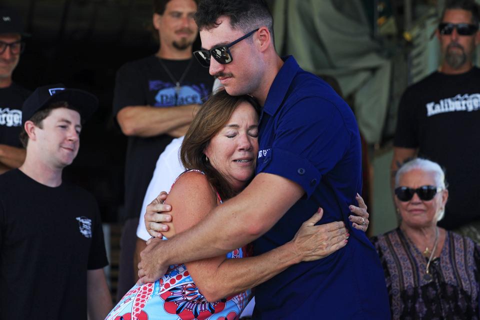 Debra Gregory hugs Coast Guard fireman Derek Altstaetter, thanking him for his part in rescuing her son Charlie in August.