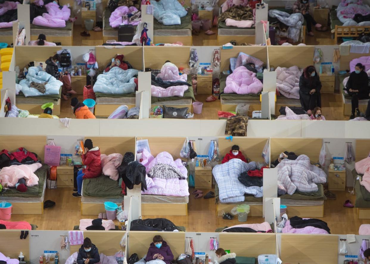 <span class="caption">Patients infected with COVID-19 rest at a temporary hospital in Wuhan, China, Feb. 17, 2020.</span> <span class="attribution"><a class="link " href="https://www.gettyimages.com/detail/news-photo/feb-17-2020-patients-infected-with-the-novel-coronavirus-news-photo/1201623090?adppopup=true" rel="nofollow noopener" target="_blank" data-ylk="slk:Getty Images/Xiao Yijiu;elm:context_link;itc:0;sec:content-canvas">Getty Images/Xiao Yijiu</a></span>