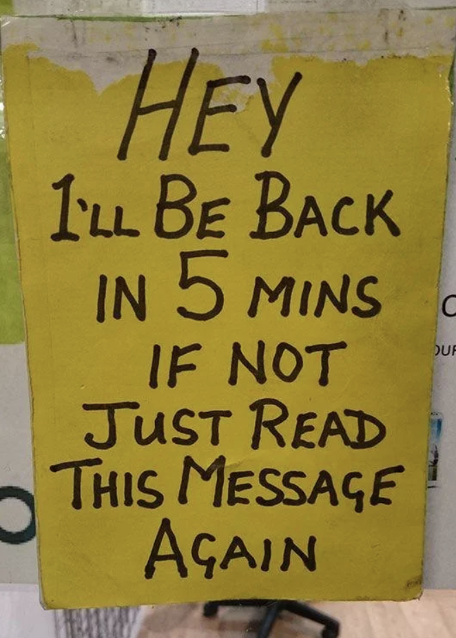 Handwritten sign saying "I'll be back in 5 mins if not read this message again."