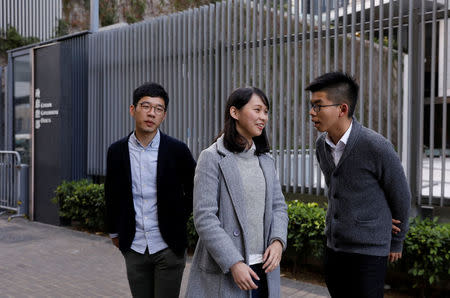 Disqualified lawmaker Nathan Law, and student activists Agnes Chow and Joshua Wong (L-R) react outside Central Government Offices in Hong Kong, China December 27, 2017. REUTERS/Tyrone Siu