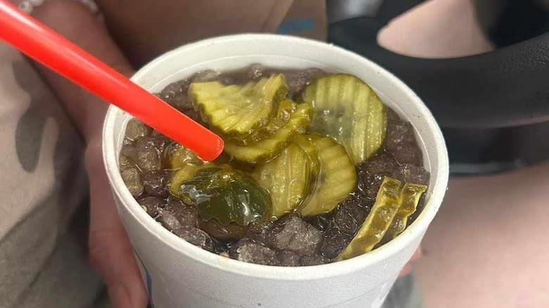 Person holding pickle dr pepper