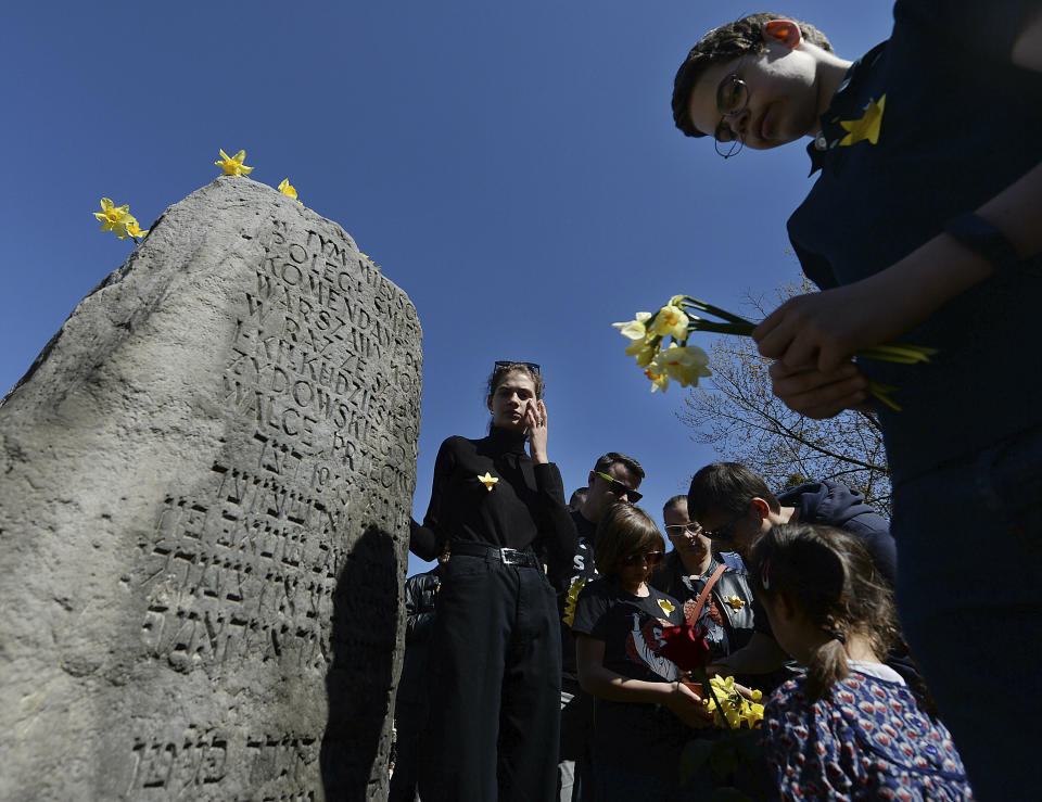 Warsaw residents lay daffodils, which have become the symbol of remembrance of the 1943 Warsaw Ghetto Uprising against the German Nazi, at a memorial site of the struggle, during anniversary observances in Warsaw, Poland, Friday, April 19, 2019.(AP Photo/Czarek Sokolowski)