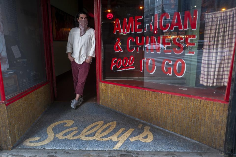 David Deluca stands in the doorway of his bar Ham and Eggs.