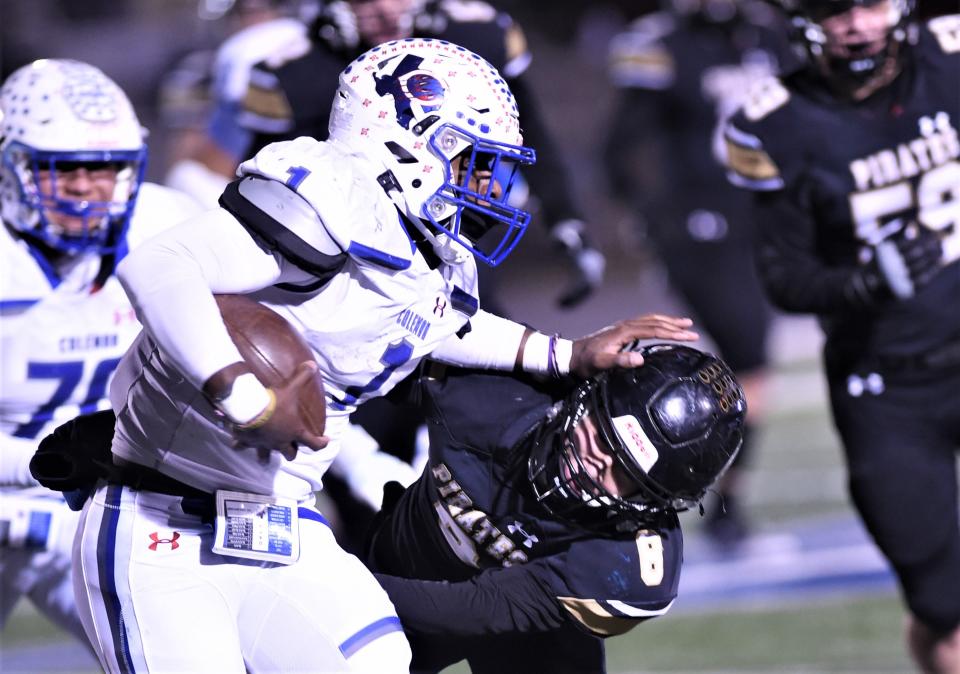 Coleman quarterback Jadin Jackson (1) pushes away a Crawford defender in the first half. Crawford won the Region II-2A DI area playoff game 34-13 on Friday, Nov. 18, 2022, at Kangaroo Stadium in Weatherford.