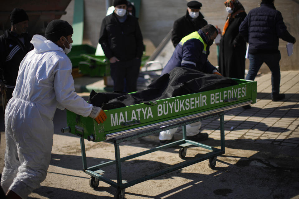 FILE - Workers carry a victim of the earthquake to the morgue at Sehir cemetery in Malatya, Turkey, on Feb. 12, 2023. A magnitude 5.6 earthquake shook southern Turkey on Monday Feb. 27, 2023 three weeks after a catastrophic temblor devastated the region, causing some already damaged buildings to collapse and killing at least one person, the country's disaster management agency, AFAD, said. (AP Photo/Francisco Seco, File)