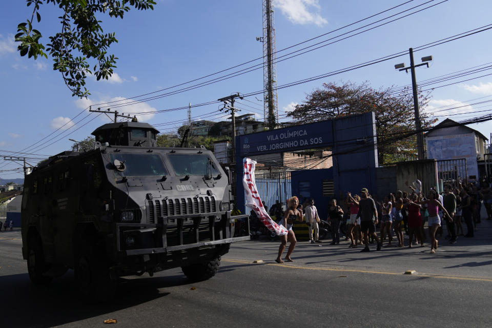 A military vehicle drives past as residents gather to protest against a police operation that resulted in multiple deaths, in the Complexo do Alemao favela in Rio de Janeiro, Brazil, Thursday, July 21, 2022. Police said in a statement it was targeting a criminal group in Rio largest complex of favelas, or low-income communities, that stole vehicles, cargo and banks, as well as invaded nearby neighborhoods. (AP Photo/Silvia Izquierdo)