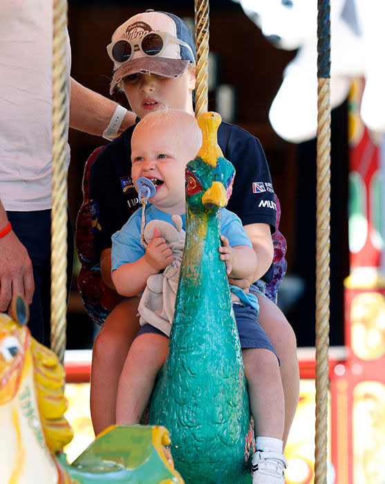 Mia Tindall holds baby brother Lucas on the carousel