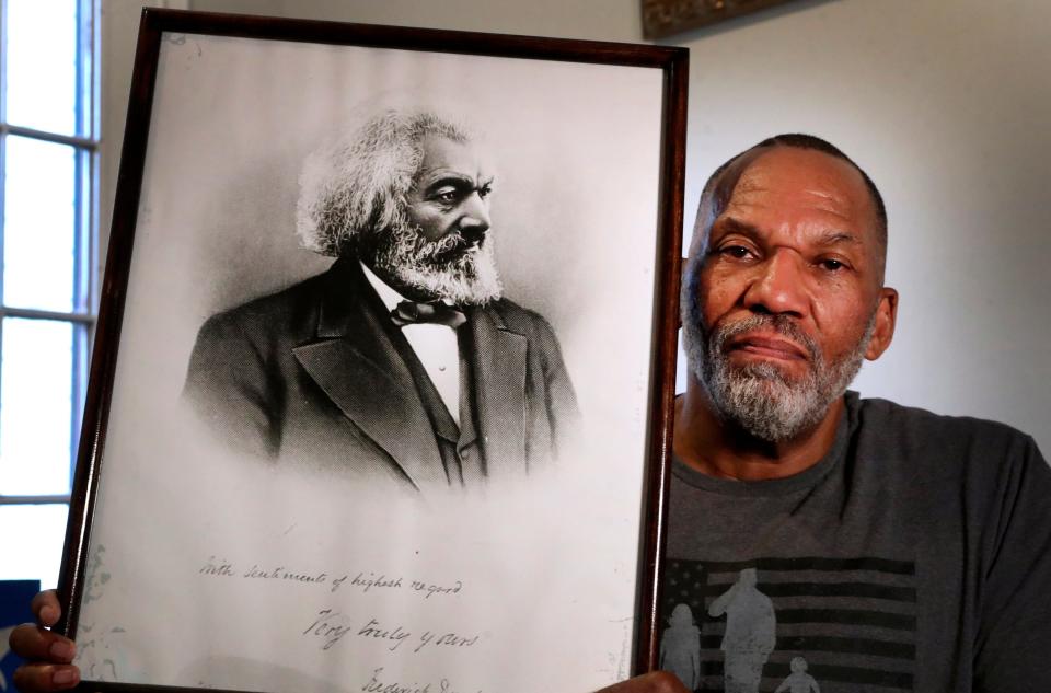 Kevin Douglass Greene the great-great-grandson of Fredrick Douglass holds up an image of his famous relative, during an interview in Greene's home, on Monday, April 25, 2022.