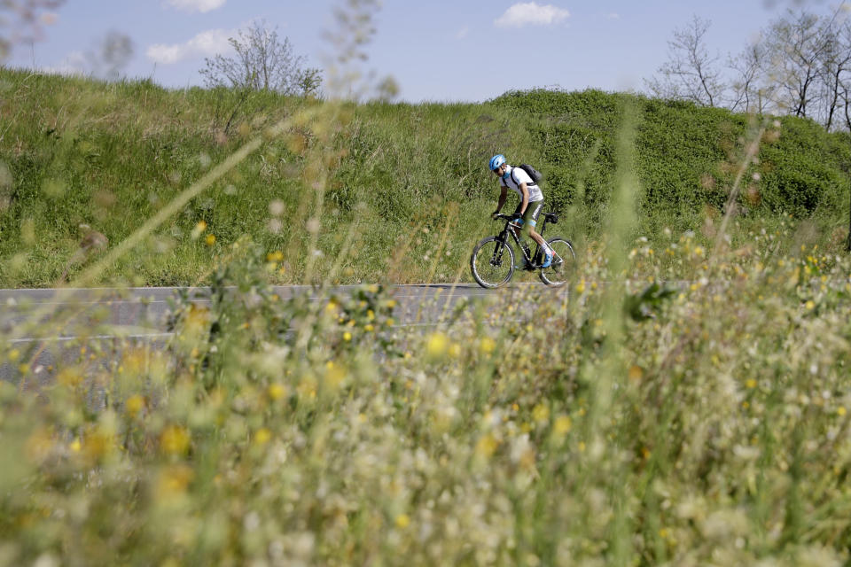 El ciclista profesional Davide Martinelli pedalea por la campiña para recoger medicinas que llevará a personas impedidas en su pueblo Lodetto, al norte de Italia, en plena pandemia del coronavirus. En Lodetto no hay farmacia y Martinelli pedalea 30 o 40 minutos hasta la farmacia del pueblo más cercano, Rovato. (AP Photo/Luca Bruno)