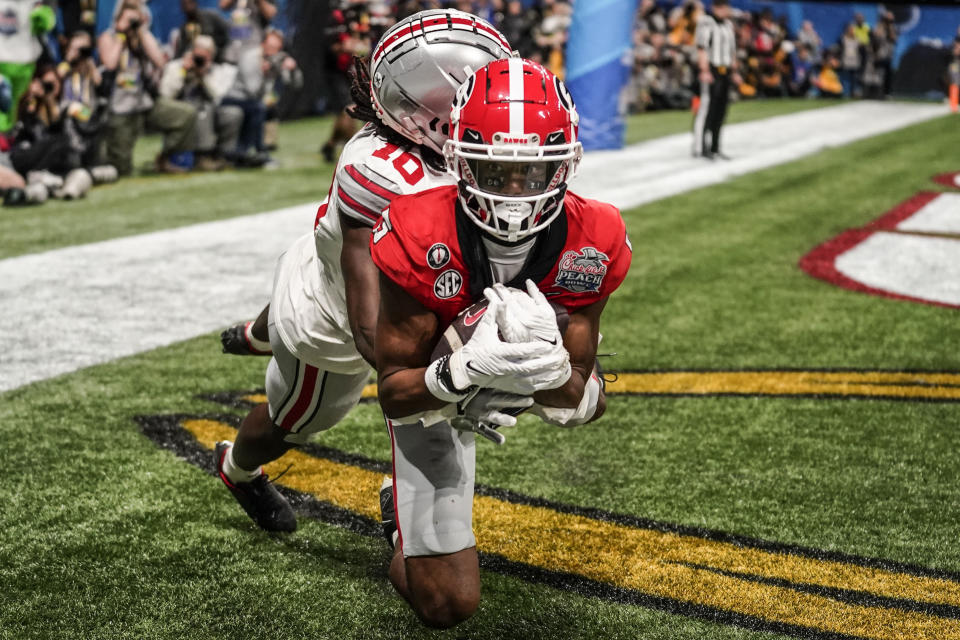 Georgia wide receiver Adonai Mitchell (5) makes a touchdown catch against Ohio State cornerback Denzel Burke (10) during the second half of the Peach Bowl NCAA college football semifinal playoff game, Saturday, Dec. 31, 2022, in Atlanta. (AP Photo/Brynn Anderson)