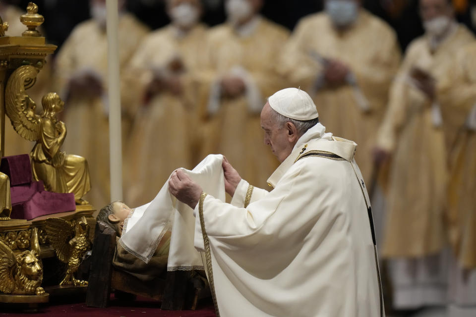 Pope Francis unveils a statue of Baby Jesus as he celebrates Christmas Eve Mass, at St. Peter's Basilica, at the Vatican, Friday Dec. 24, 2021. (AP Photo/Alessandra Tarantino)