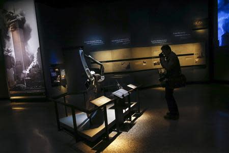 A member of the media take a photo in the historical exhibition section of the National September 11 Memorial & Museum during a press preview in New York May 14, 2014. REUTERS/Shannon Stapleton